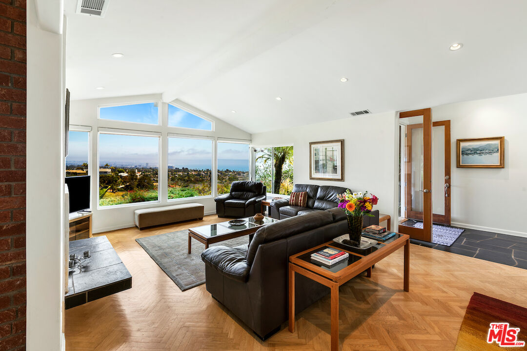 1336 Las Canoas Road Pacific Palisades, CA 90272 - Photo 10 of 37 a living room with furniture and a floor to ceiling window