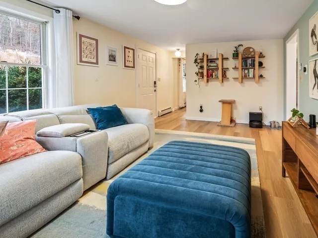 a bedroom with a bed a desk and chair with wooden floor