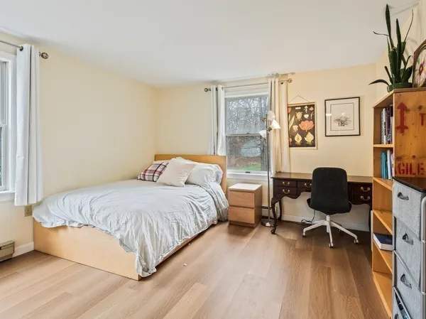 a view of a bedroom with wooden floor and windows