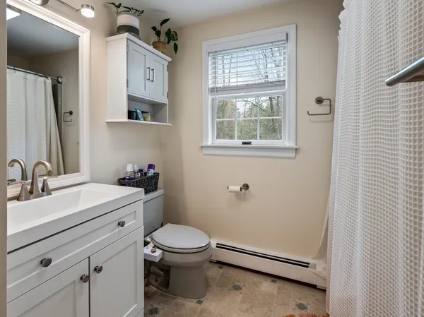 a spacious bedroom with a bed and wooden floor