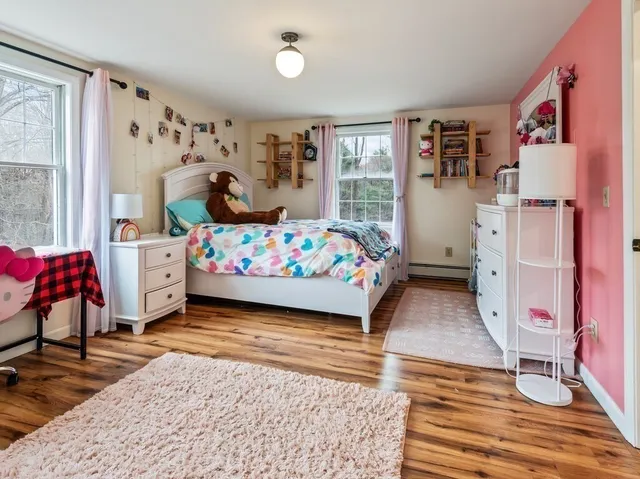 a bedroom with bed and wooden floor