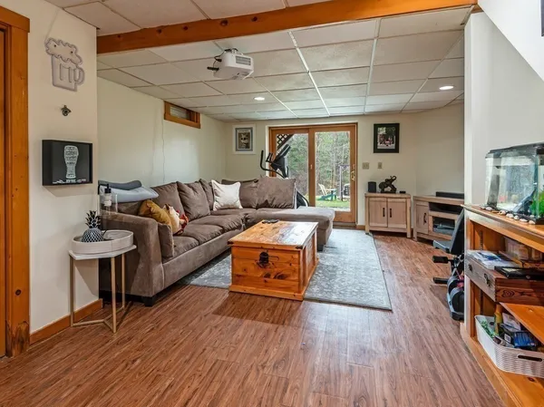a living room with furniture a flat screen tv and gym equipment