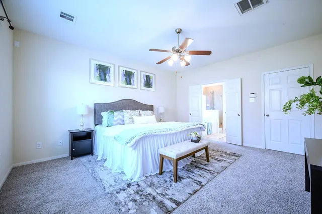 a spacious bedroom with a bed and a chandelier