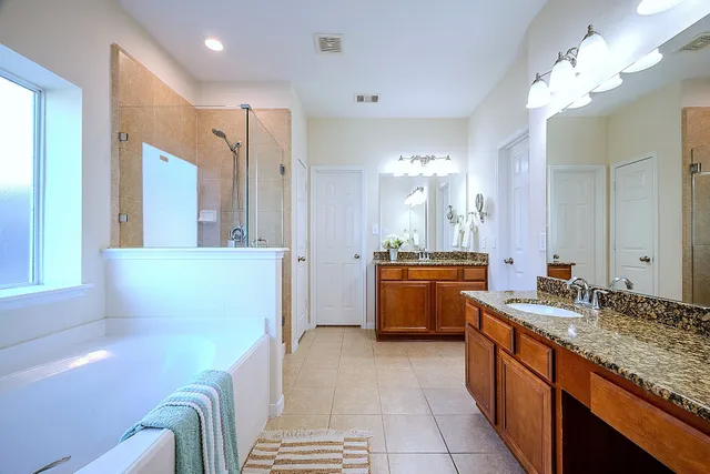 a large bathroom with double vanity and a bathtub