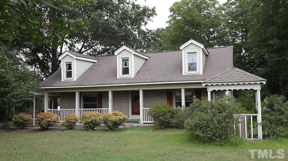 1390 Sanders Road Benson, NC 27504 - Photo 1 of 22 a front view of a house with a garden and porch