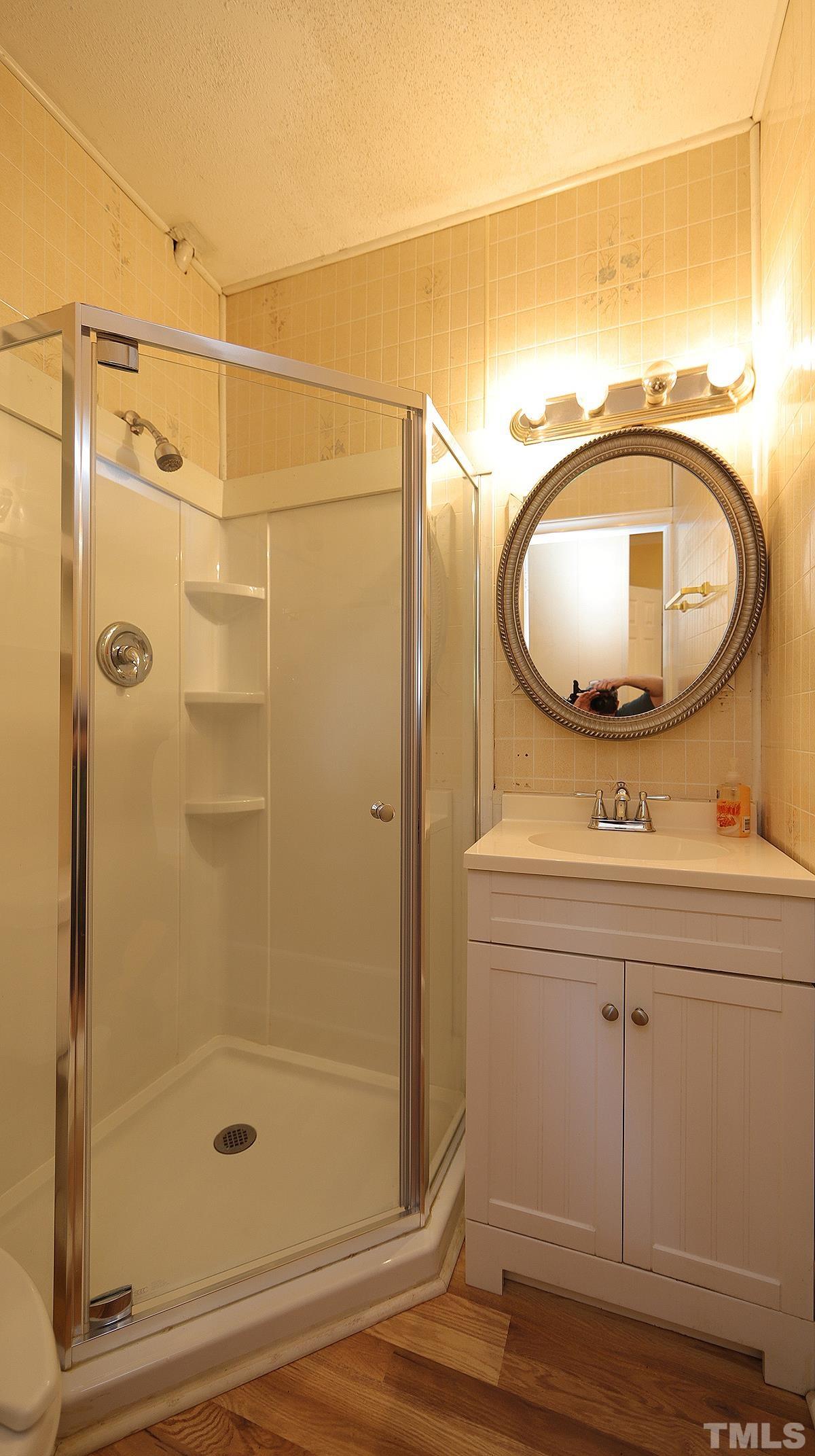 1390 Sanders Road Benson, NC 27504 - Photo 12 of 22 a bathroom with a sink and a mirror