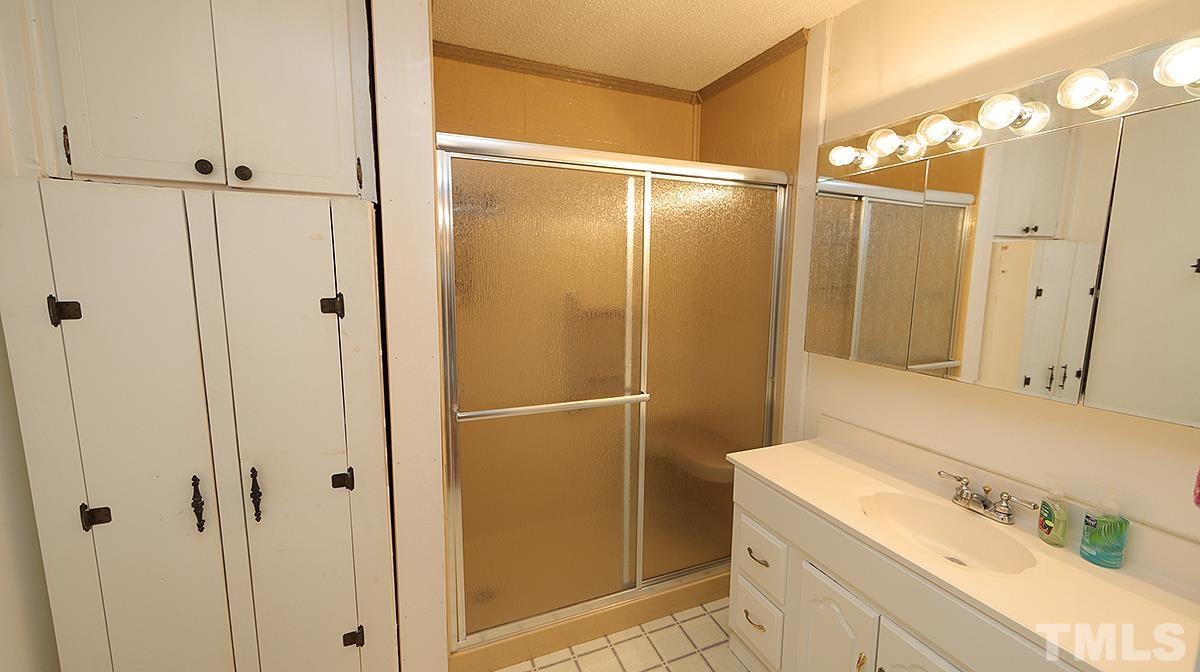 1390 Sanders Road Benson, NC 27504 - Photo 14 of 22 a bathroom with a shower and a sink