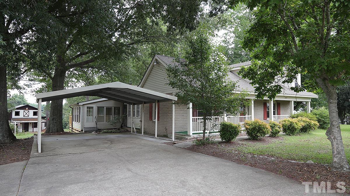 1390 Sanders Road Benson, NC 27504 - Photo 2 of 22 a front view of a house with a garden