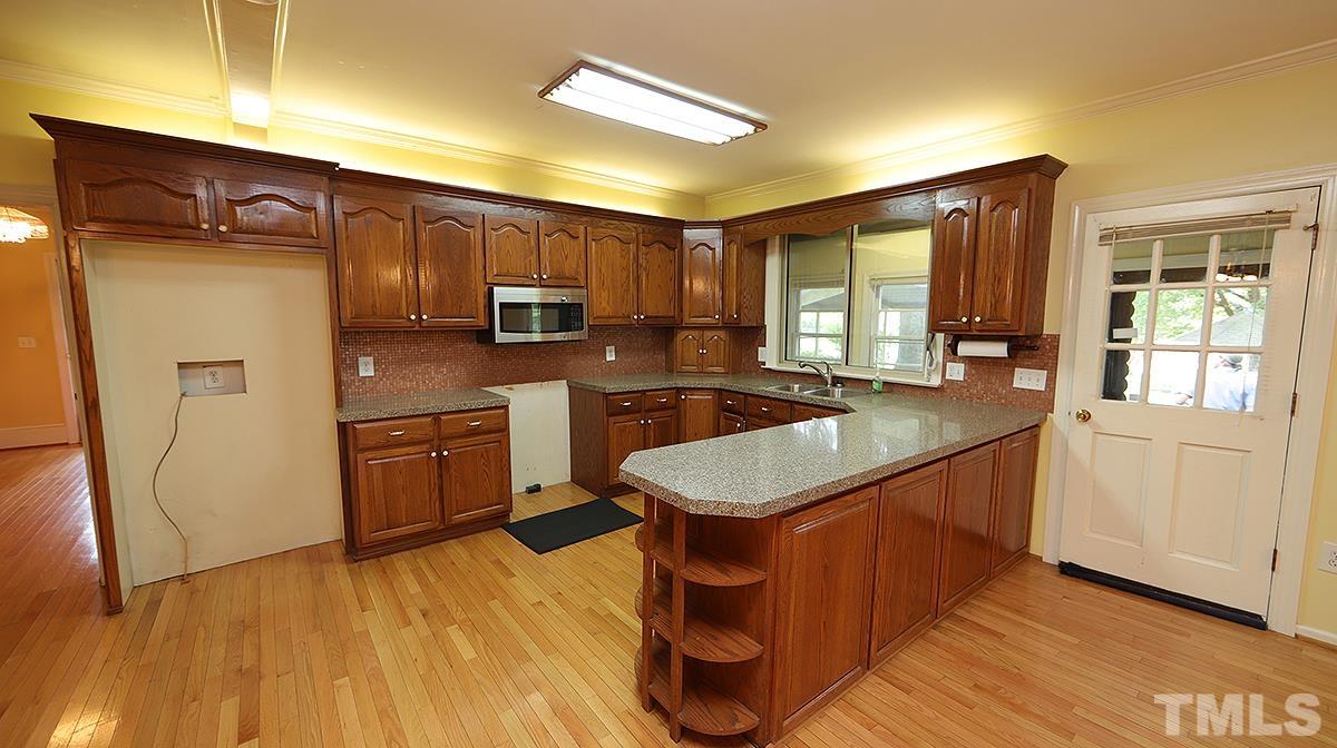 1390 Sanders Road Benson, NC 27504 - Photo 3 of 22 a kitchen with stainless steel appliances granite countertop a sink stove and refrigerator