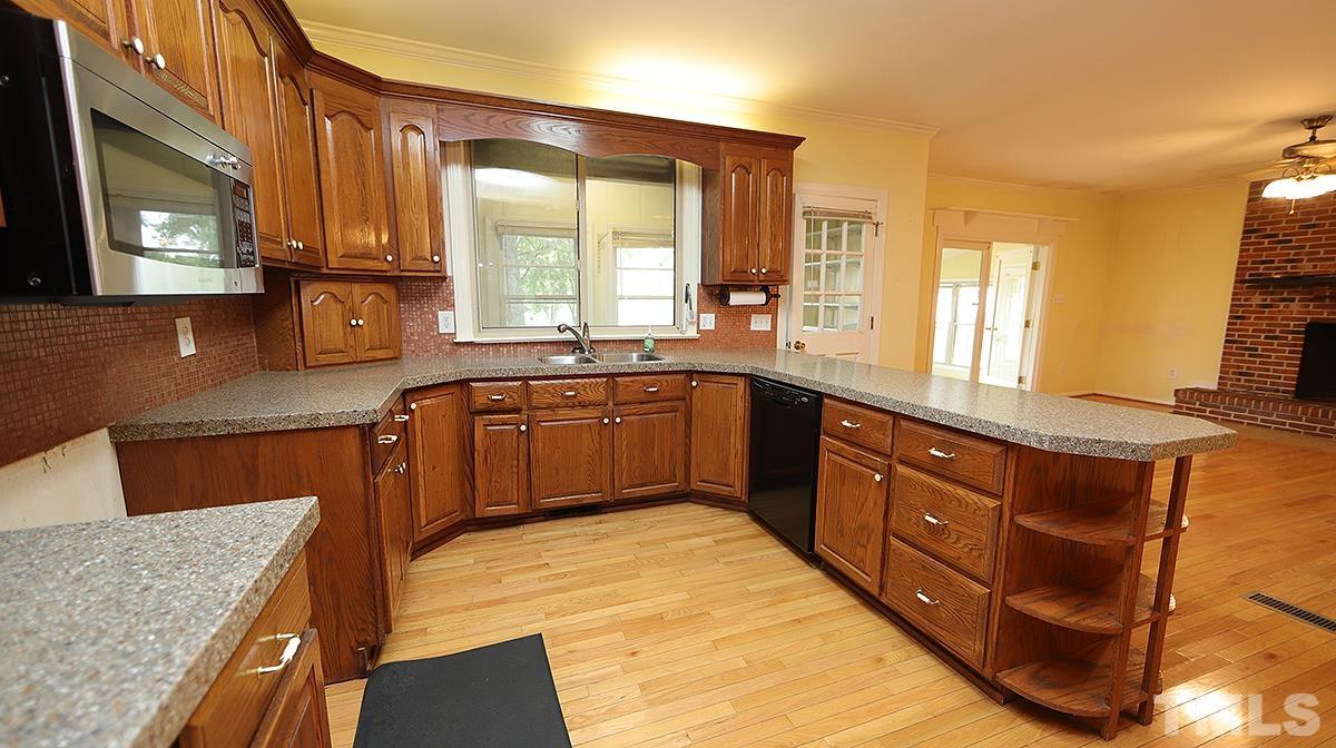 1390 Sanders Road Benson, NC 27504 - Photo 4 of 22 a kitchen with stainless steel appliances granite countertop sink stove and cabinets