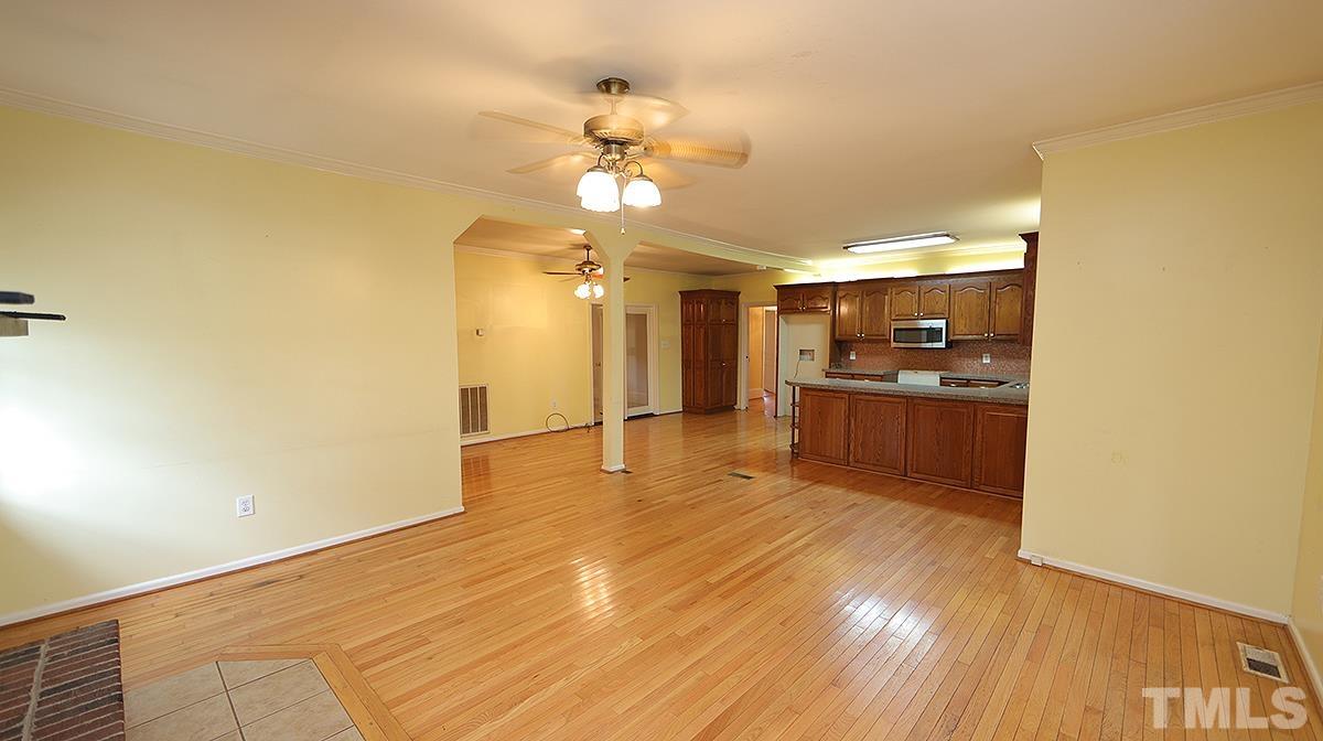 1390 Sanders Road Benson, NC 27504 - Photo 7 of 22 a view of a big room with wooden floor and a kitchen