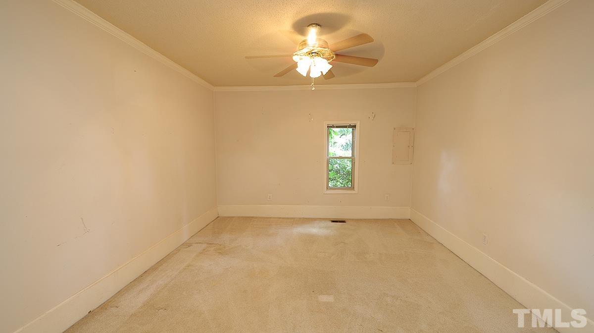 1390 Sanders Road Benson, NC 27504 - Photo 9 of 22 an empty room with a chandelier fan and windows