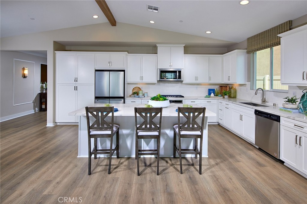 30934 Campania Road Highland, CA 92346 - Photo 6 of 19 a kitchen with stainless steel appliances a dining table chairs stove microwave and cabinets