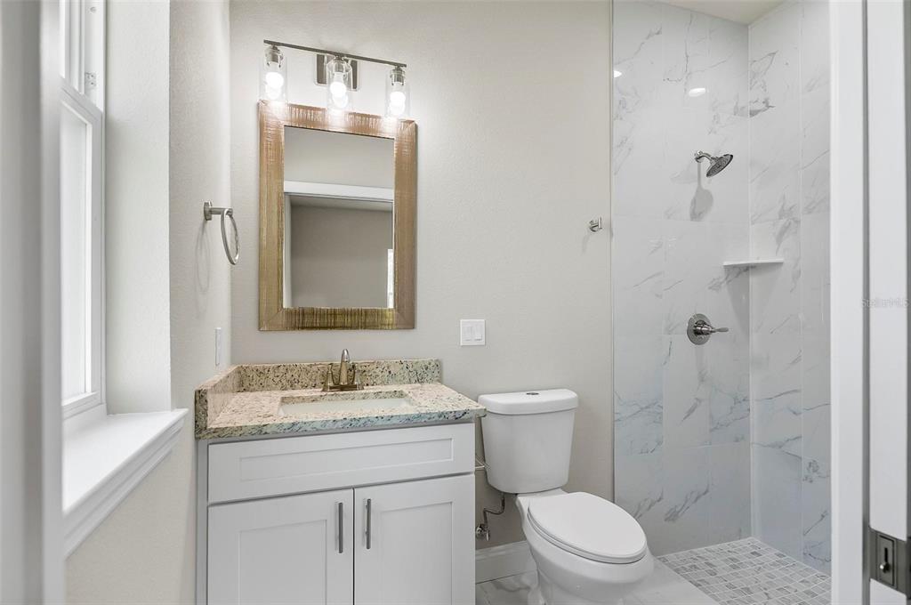 43 Eton Lane, Unit A Palm Coast, FL 32164 - Photo 21 of 78 a bathroom with a granite countertop sink toilet and shower