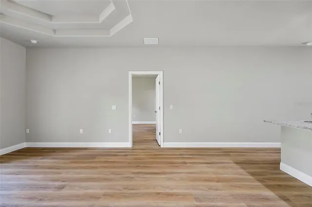 an empty room with wooden floor and window