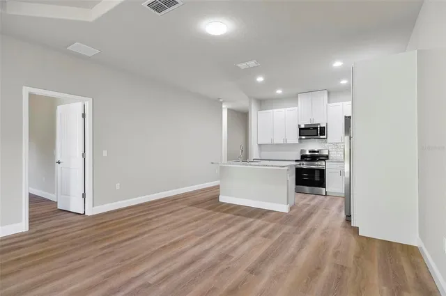 a view of a room with wooden floor and a bathroom