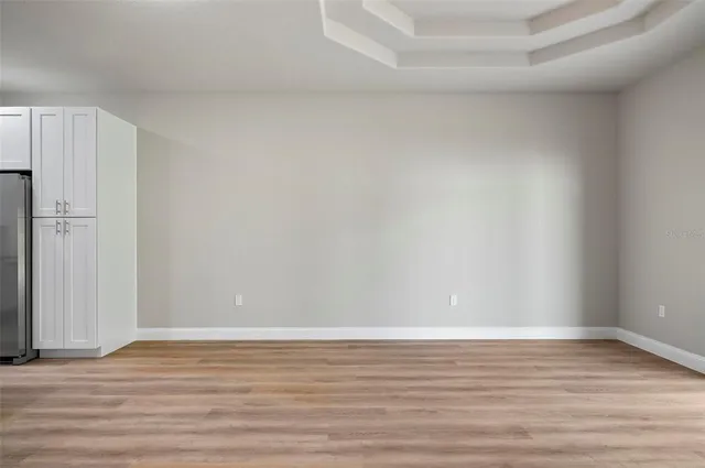 a view of an empty room with wooden floor