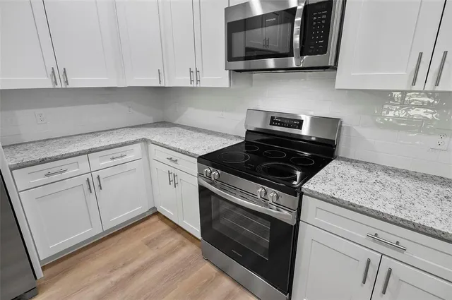 a kitchen with stainless steel appliances granite countertop a refrigerator sink and cabinets