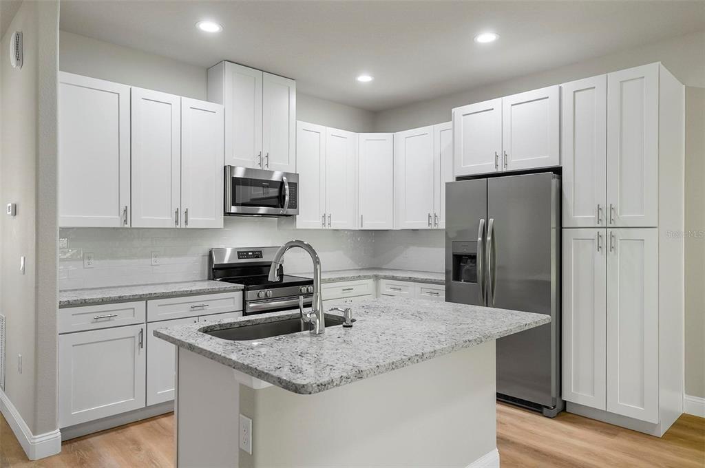 43 Eton Lane, Unit A Palm Coast, FL 32164 - Photo 6 of 78 a kitchen with stainless steel appliances granite countertop a refrigerator sink and cabinets