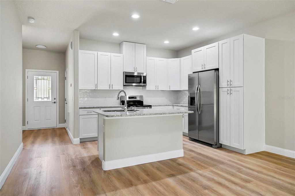 43 Eton Lane, Unit A Palm Coast, FL 32164 - Photo 74 of 78 a kitchen with a refrigerator a stove top oven and wooden floor