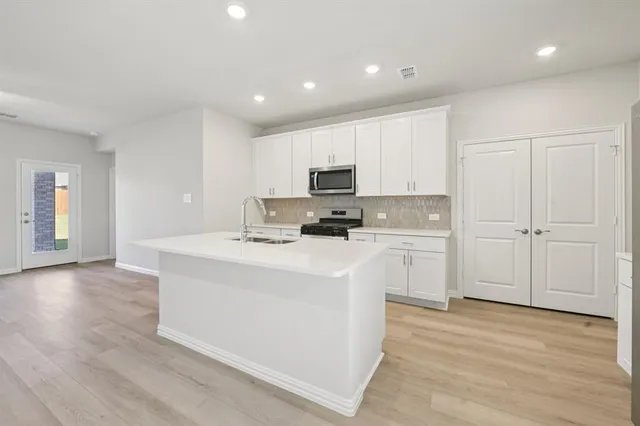 a kitchen with a sink a stove top oven and white kitchen
