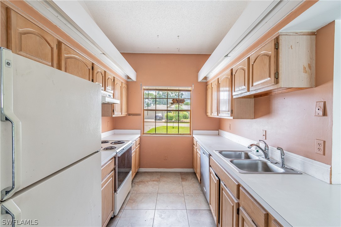 17552 Lebanon Road Fort Myers, FL 33967 - Photo 32 of 35 a kitchen with stainless steel appliances granite countertop a sink stove and refrigerator