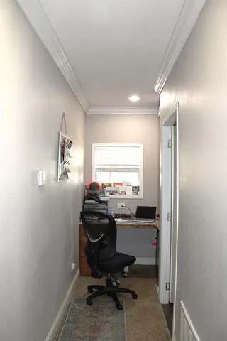 a view of a workspace with furniture and a window