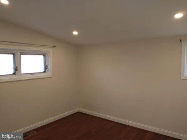 a view of a small space with wooden floor and a window