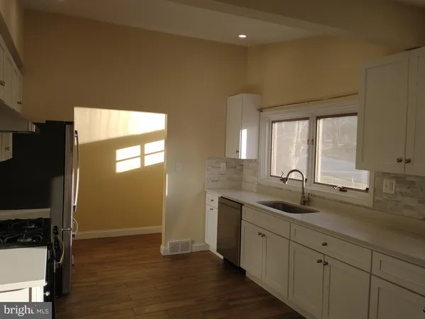 a kitchen with a sink cabinets and wooden floor