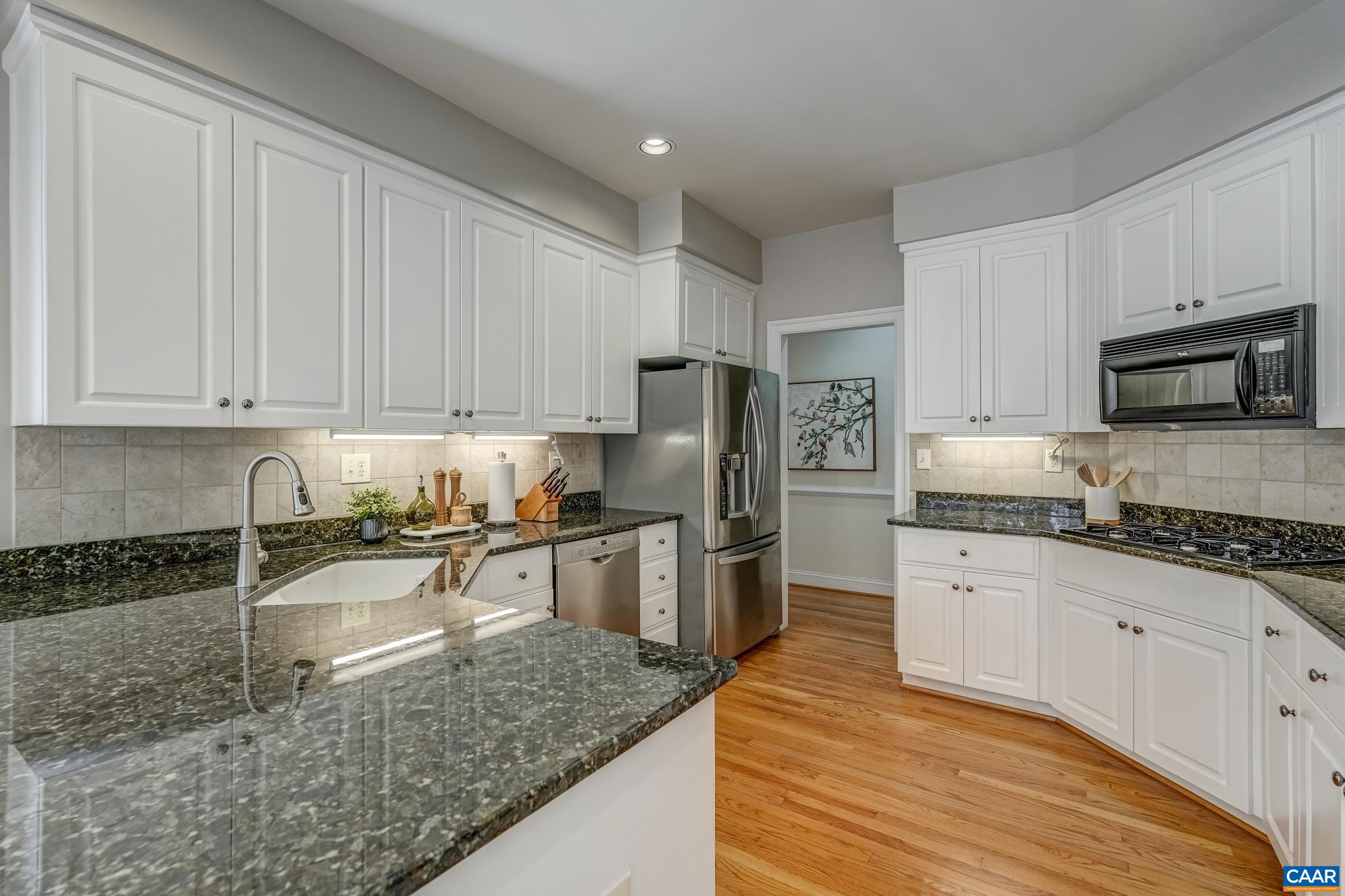 3434 Darby Road Keswick, VA 22947 - Photo 17 of 45 a kitchen with granite countertop a sink a stove top oven a refrigerator and white cabinets