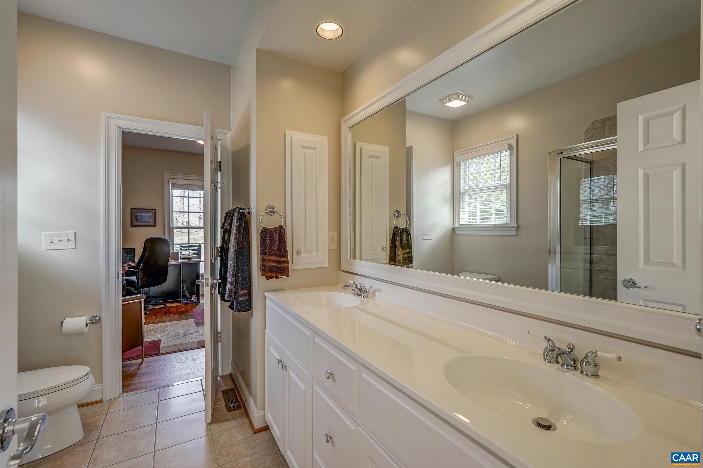 3434 Darby Road Keswick, VA 22947 - Photo 27 of 45 a spacious bathroom with a shower sink and mirror