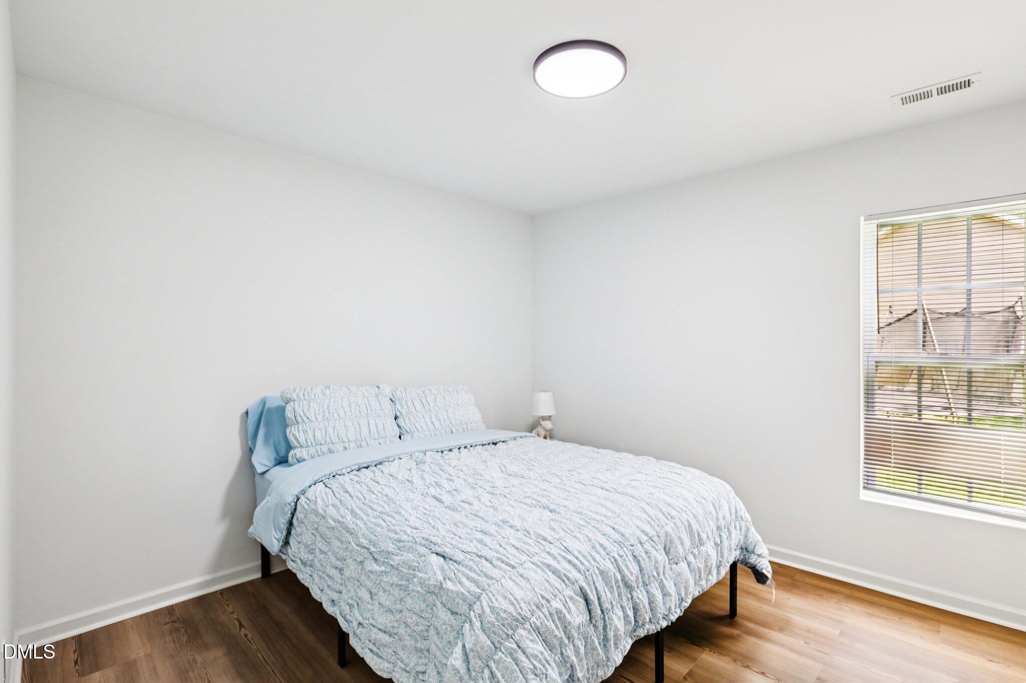 1349 Crabtree Boulevard Raleigh, NC 27610 - Photo 13 of 21 a bedroom with a bed and wooden floor