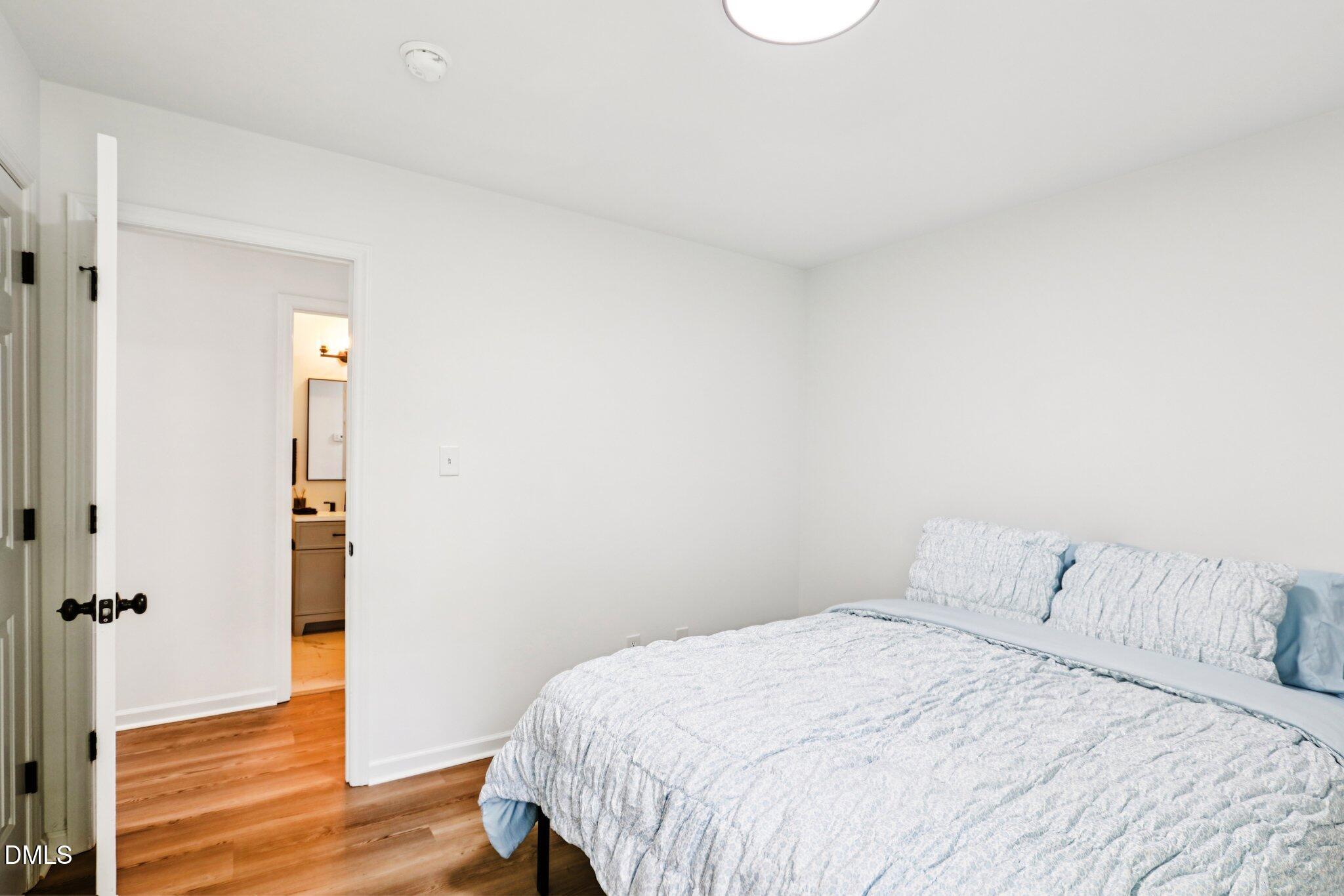 1349 Crabtree Boulevard Raleigh, NC 27610 - Photo 15 of 21 a bedroom with a bed and wooden floor