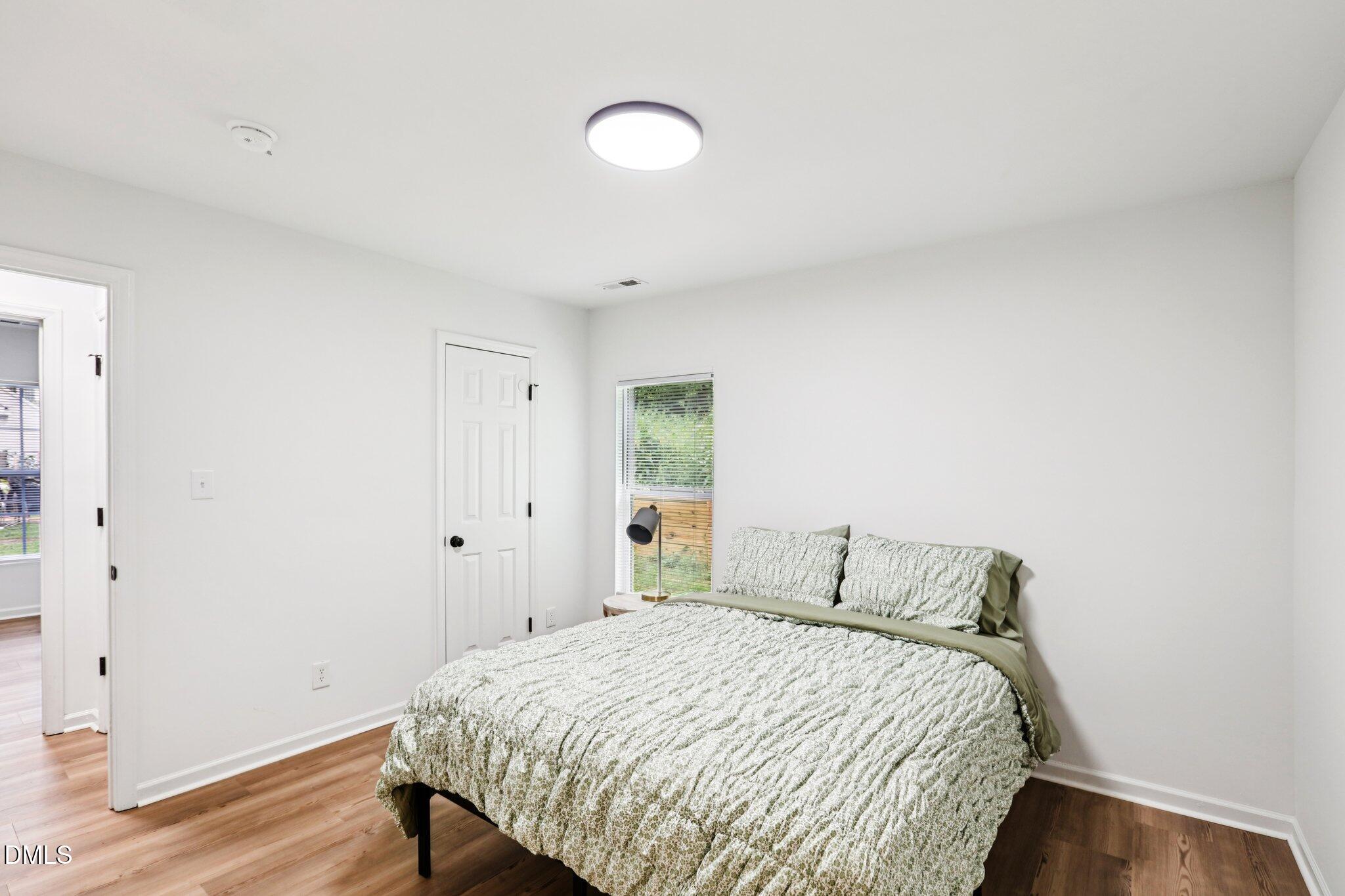 1349 Crabtree Boulevard Raleigh, NC 27610 - Photo 10 of 21 a bedroom with a bed and wooden floor