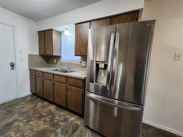 a kitchen with stainless steel appliances granite countertop a refrigerator and a sink