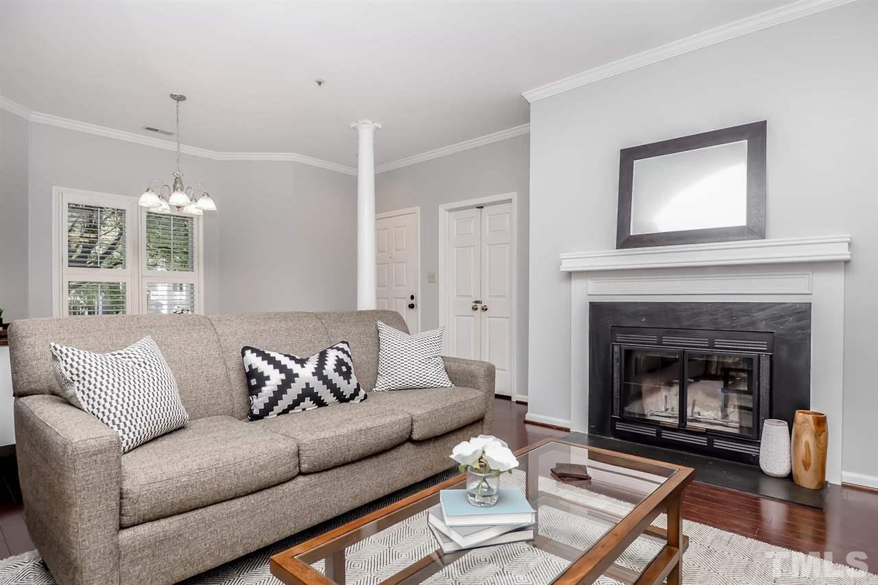 1001 Brighthurst Drive, Unit 103 Raleigh, NC 27605 - Photo 2 of 16 a living room with furniture and a fireplace