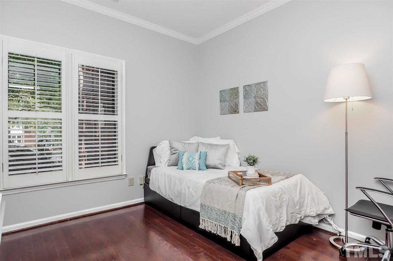 1001 Brighthurst Drive, Unit 103 Raleigh, NC 27605 - Photo 12 of 16 a bedroom with a bed and a lamp