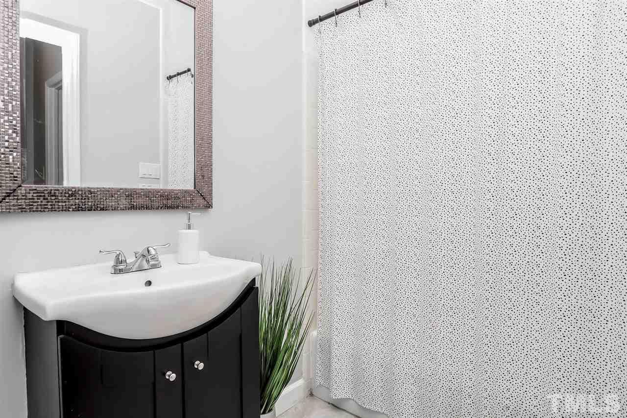 1001 Brighthurst Drive, Unit 103 Raleigh, NC 27605 - Photo 14 of 16 a bathroom with a sink and a mirror