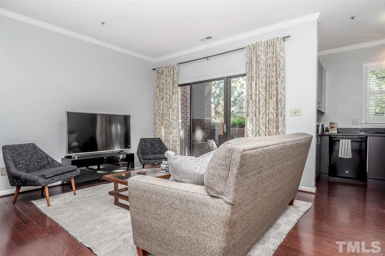 1001 Brighthurst Drive, Unit 103 Raleigh, NC 27605 - Photo 3 of 16 a living room with furniture and a flat screen tv