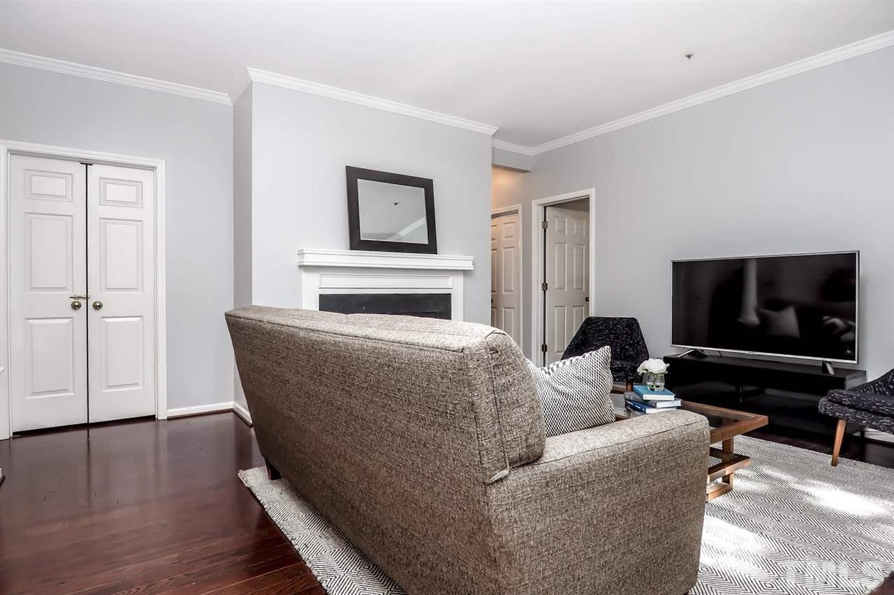 1001 Brighthurst Drive, Unit 103 Raleigh, NC 27605 - Photo 4 of 16 a living room with furniture and a flat screen tv