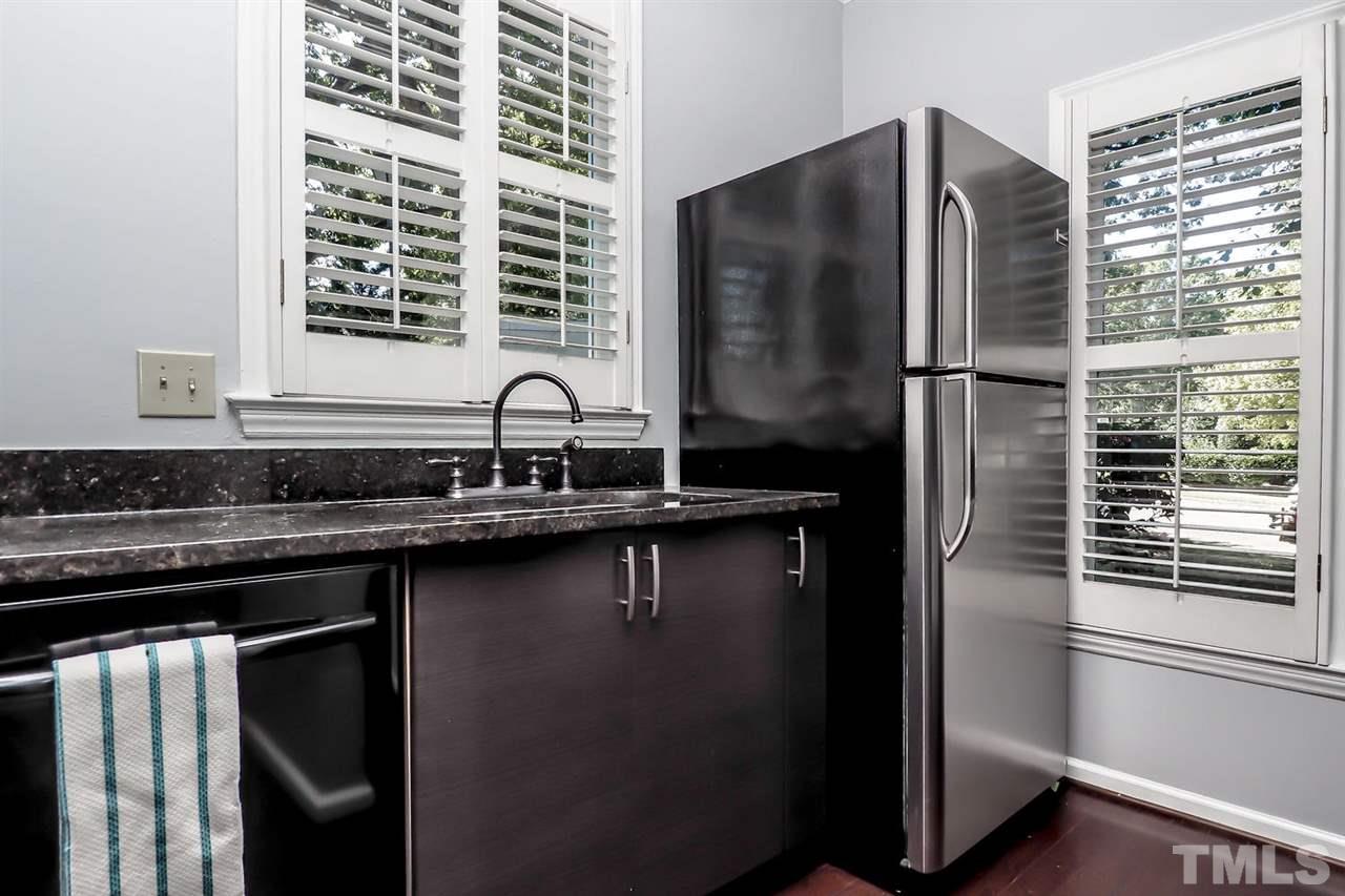 1001 Brighthurst Drive, Unit 103 Raleigh, NC 27605 - Photo 9 of 16 a kitchen with a refrigerator and a sink