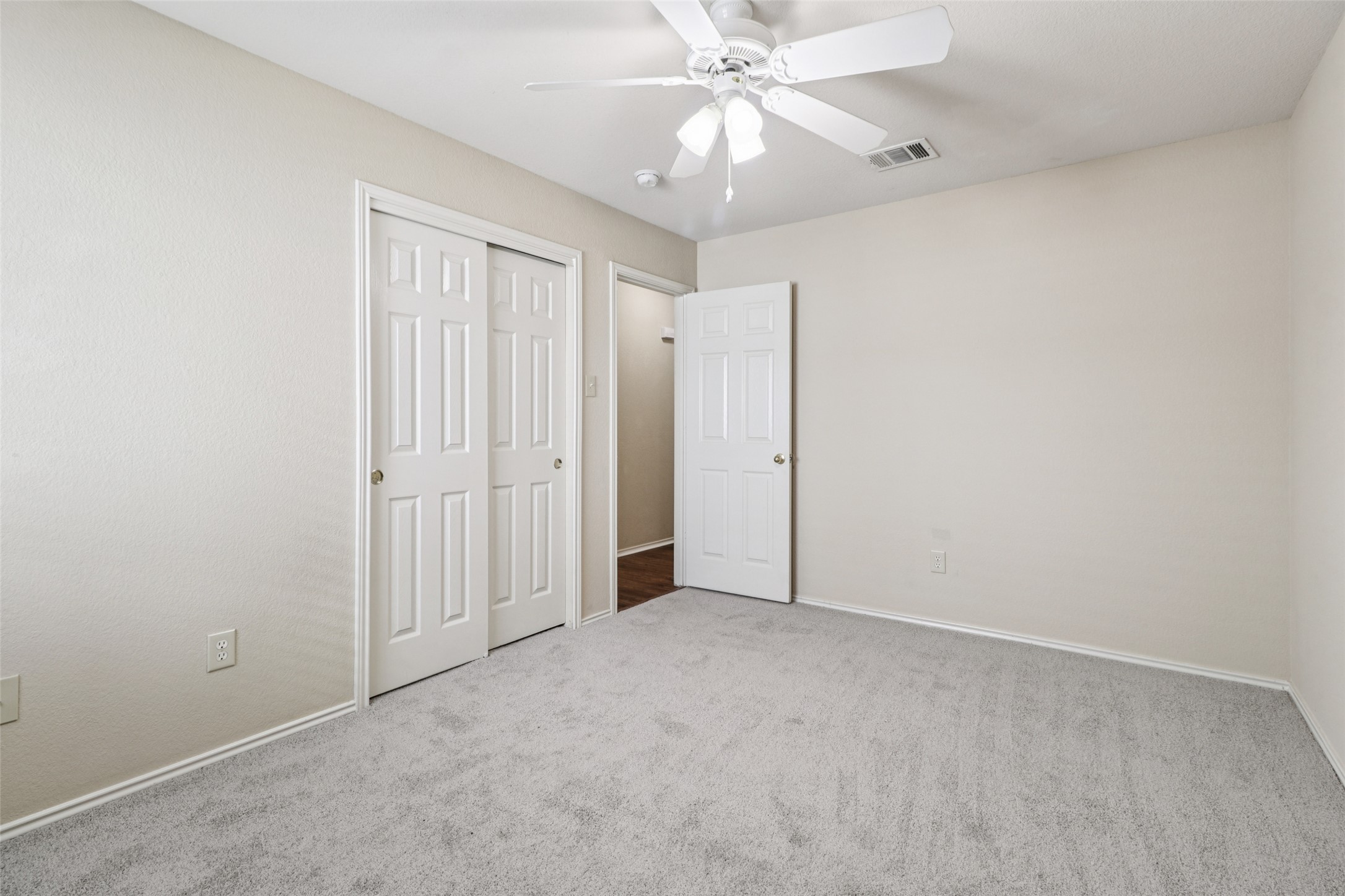 700 Scheel Road Kyle, TX 78640 - Photo 32 of 39 This room features a ceiling fan with integrated lighting, a neutral color palette on the walls, and light-colored carpeting