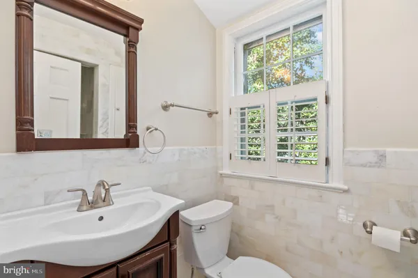 a bathroom with a sink a toilet and a mirror