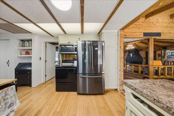 a kitchen with granite countertop stainless steel appliances a refrigerator and a stove