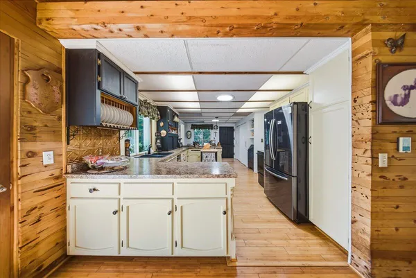 a room with stainless steel appliances kitchen island granite countertop a refrigerator and a stove top oven