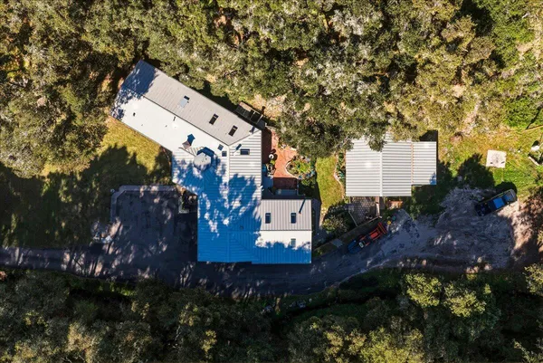 a aerial view of a house with a yard and large trees