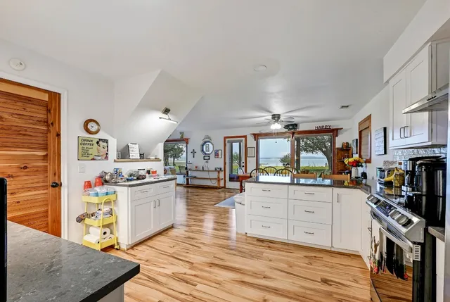 a kitchen with stainless steel appliances granite countertop a stove oven and a cabinets with wooden floor