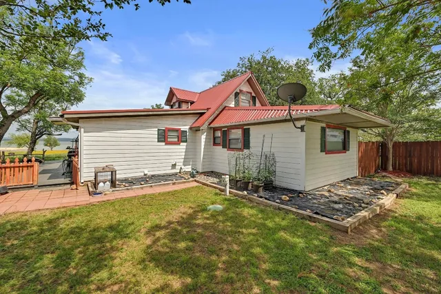 a backyard of a house with table and chairs