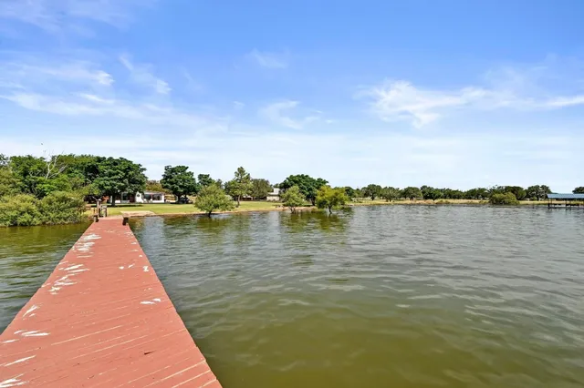 a wooden pier with boats in a lake