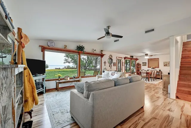 a living room with furniture a flat screen tv and a large window